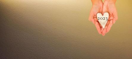 hand holding heart 2023 top view and white background with shadow photo