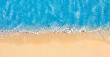 Summer seascape beautiful waves, blue sea water in sunny day. Top view from drone. Sea aerial view, amazing tropical nature background. Beautiful bright sea waves splashing and beach sand sunset light photo