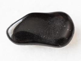 polished black obsidian gemstone on white photo