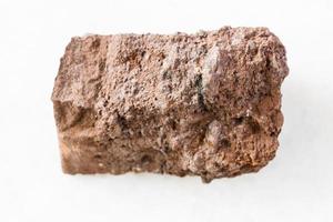 roca de bauxita sin pulir sobre mármol blanco foto