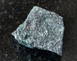 mineral de magnetita en bruto sobre negro foto