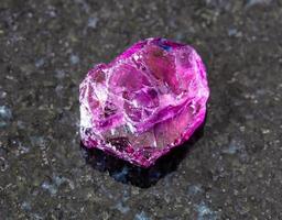 raw Rhodolite pyrope garnet crystal on black photo