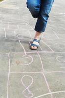girl hops in hopscotch outdoors photo