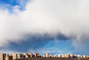 big snow cloud over city in sunny day photo
