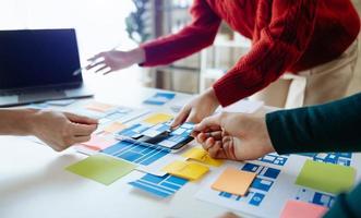 UX developer and ui designer brainstorming about mobile app interface wireframe design with customer breif and color code at modern office. photo