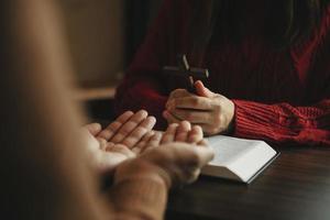 dos personas leyendo y estudiando la biblia en casa y orando juntas. estudiando la palabra de dios