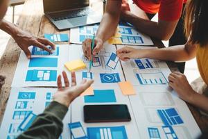 UX developer and ui designer brainstorming about mobile app interface wireframe design with customer breif and color code at office. photo