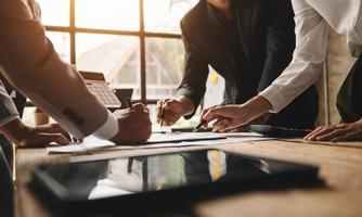 Business documents on office table with smart phone and calculator digital tablet and graph business with social network diagram and two colleagues discussing data working in the office photo