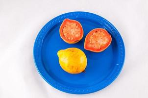 Tomato and lemon on plate photo