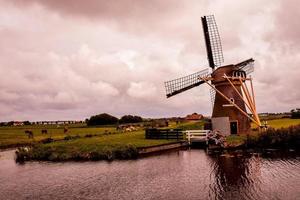 Windmill by water photo