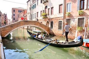 Unidentified people in a gondola in Venice, Italy, circa June 2022 photo