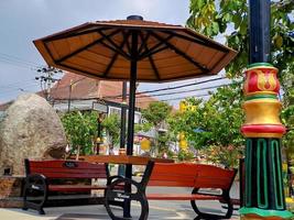 resting place benches and umbrellas made of black brown wood and iron, bright blue sky in the garden of the city of Madiun Indonesia. photo