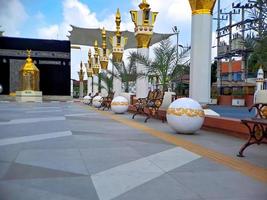 brown gold white color mosque minaret with arabic architecture in madiun indonesia park, sunny weather. photo