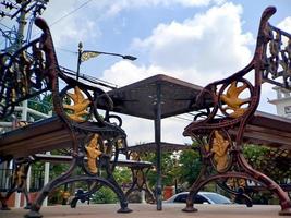 banco tallado de hierro dorado marrón con arquitectura árabe en el parque madiun indonesia, clima soleado. foto