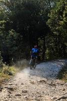 Bicyclist on dirt road photo