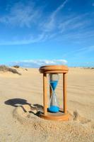 Hourglass in sand photo