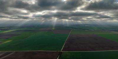 panorama of black sky background with storm clouds. thunder front over fields with sun rays photo