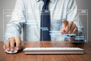 Project manager analyst working with computer in management system to progress planning and make report with KPI chart scheduling diagram.Corporate strategy for finance, sales, marketing. photo