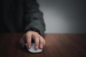 Hand using computer mouse, clicking pointer laptop on desk. photo