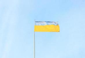 Ukrainian blue and yellow flag in the wind. Background of blue sky and light white clouds. The national flag of Ukraine photo