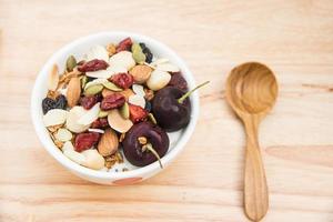 Healthy food, granola, organic super food with honey, dried fruits and nuts with yogurt and blur wooden spoon photo