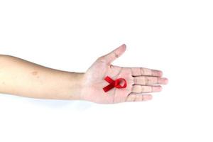 hand symbol with red ribbon signifying concern for people with HIV aids isolated on white background photo