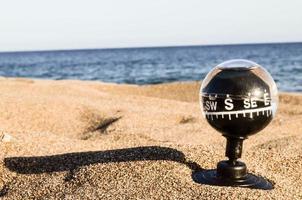 Compass on the ground by the ocean photo