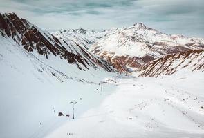 vista aérea de los remontes en kobi en la estación de esquí de gudauri. montañas blancas y ascensor de cabina en la estación de esquí de vacaciones de invierno foto