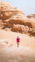 Happy joyful woman tourist stand with hands up on wadi rum desert on hike on holiday vacation in Wadi rum. Popular Wadi Rum desert in Jordan photo