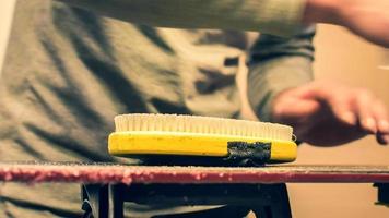 Yellow brush lay on snowboard while waxing snowboard preparation for season photo