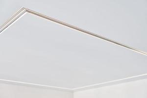 Suspended ceiling with LED strip lamp in empty room, repair photo