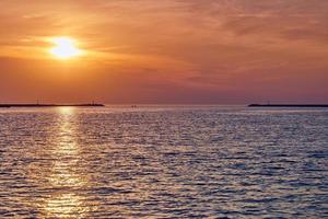 Calm sea with sunset sky, beautiful panoramic view, amazing dramatic rising sun reflected in water photo