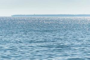 Sunny seascape. Part of the peninsula in the distance. Calm and good weather. No wind photo