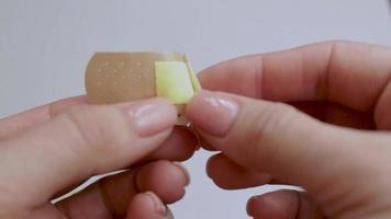 A man opens a Adhesive plaster. First aid for trauma. The medicine. Isolated background. Video. video