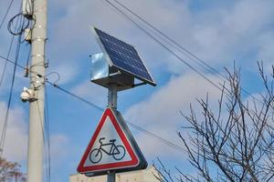 Solar panel on city road sign post, power for bus stop light, environmental friendly electricity photo
