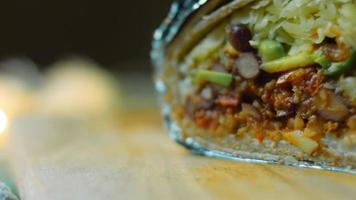 Very large burrito with avocado and chorizo meat. Filming in a romantic setting. Macro shooting video