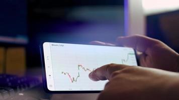 Bitcoin cryptocurrency price graph chart on mobile phone screen, cryptocurrency future price prediction concept video