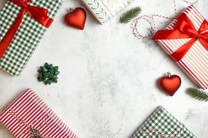 Winter holidays flat banner with place for text. Colorful presents in red,white and green with ornaments on concrete background photo