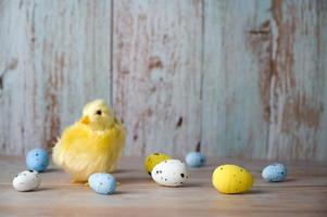 Easter greeting card with plave for text.small chicken surrounded with colorful eggs against blue background photo