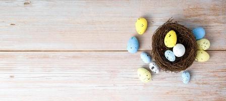 Top view on white,yellow and blue eggs in th nest Happy easter banner.Banner with place for text photo