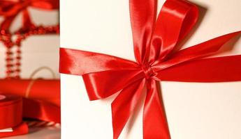 Packed gift with red bow.Wrapping paper,decoration in the background. Christmas concept. photo