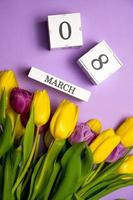 tiro vertical con plano del día de la mujer. Calendario del 8 de marzo cerca de un ramo de flores. foto