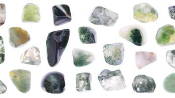 Moss agate jewel stones set texture on light white isolated background. Macro closeup. Moving right seamless loop backdrop. video