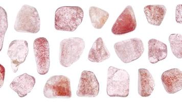 Strawberry quartz jewel stones set texture on light white isolated background. Macro closeup. Moving right seamless loop backdrop. video