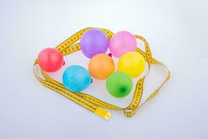 globos de colores rodeados de cinta métrica con fondo de fiesta de celebración