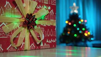 presente de natal e pinheiro decorado em uma aconchegante sala de estar em casa de inverno durante a noite de véspera de natal. luzes coloridas em movimento. video