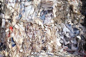 Wastepaper compact texture pile for recycling on sorting plant. Technology of reuse materials. Stack of shredded paper. Save the planet ecology concept. Industry of reduced pollution factory. Close-up photo