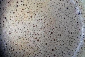 Macro photography of Cappuccino milk foam in a glass