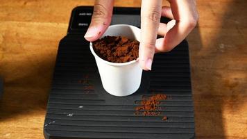 Preparation of ground coffee by baristas on the wooden table photo