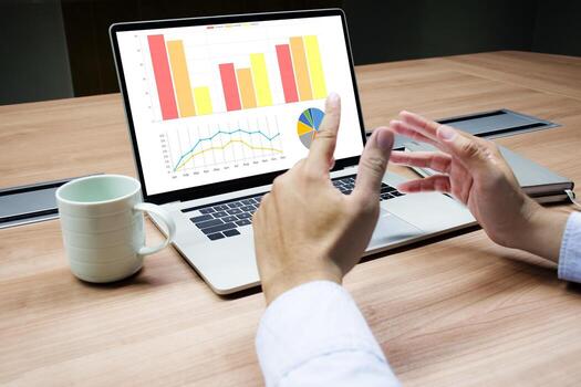 Businessman raise your hand to explain with mock up chart slide show presentation on display laptop on table photo